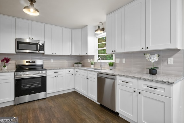 kitchen with tasteful backsplash, sink, white cabinets, and stainless steel appliances