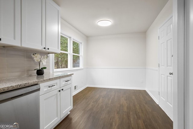 kitchen with dishwasher, light stone counters, white cabinetry, and dark wood-type flooring