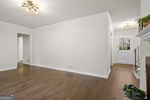 unfurnished living room with dark hardwood / wood-style flooring, crown molding, and a chandelier