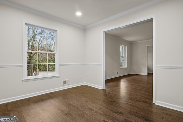 empty room with dark hardwood / wood-style flooring and ornamental molding