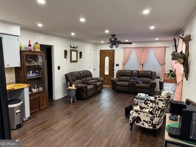 living room with ceiling fan and dark wood-type flooring