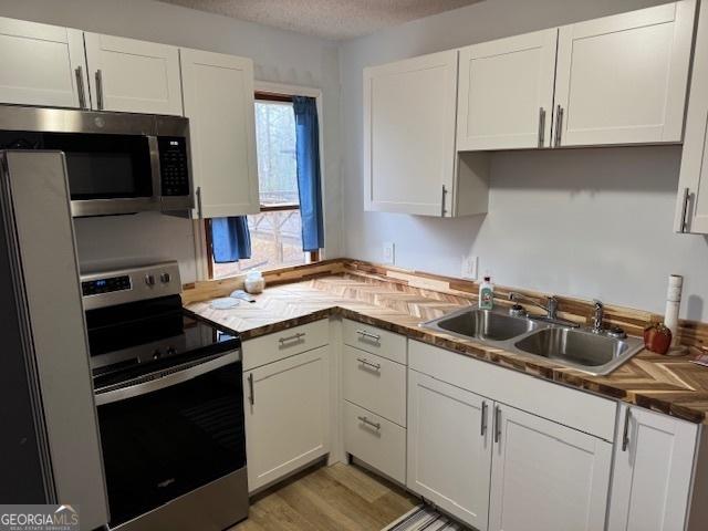 kitchen featuring white cabinets, appliances with stainless steel finishes, and sink