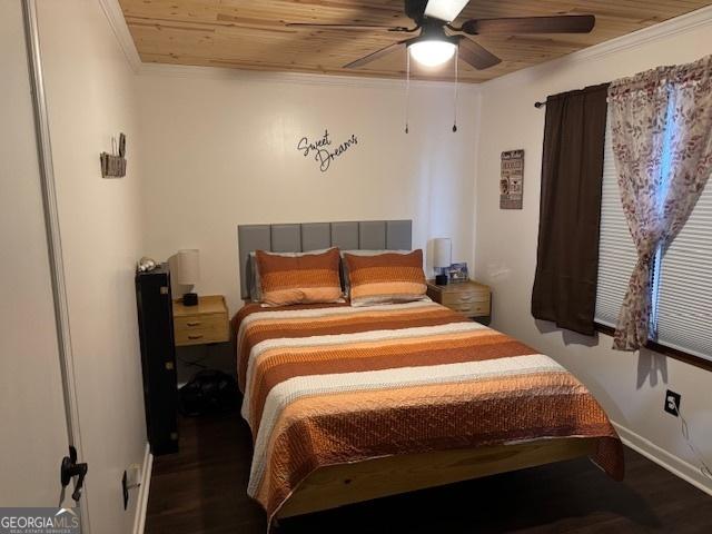 bedroom featuring dark hardwood / wood-style flooring, ceiling fan, crown molding, and wood ceiling