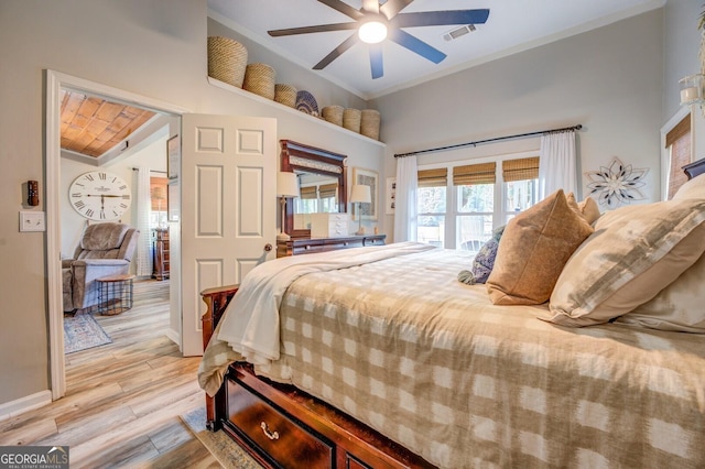 bedroom featuring ceiling fan, light wood-type flooring, and crown molding