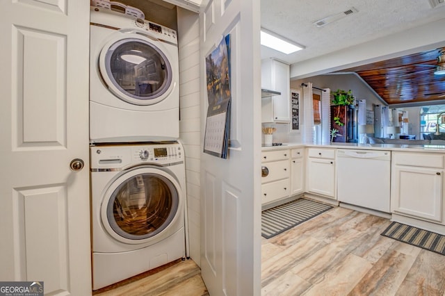 laundry room featuring stacked washer / dryer, wooden ceiling, a textured ceiling, and light hardwood / wood-style floors