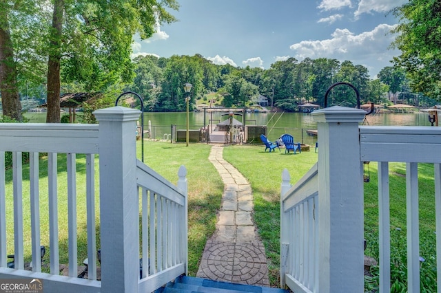 view of yard with a water view and a dock