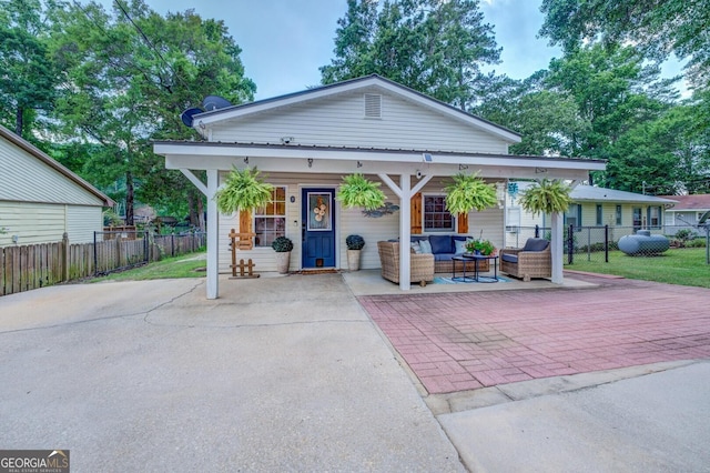 bungalow with an outdoor living space and a patio area