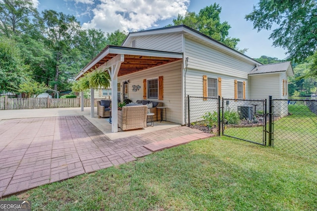 rear view of house with an outdoor hangout area, a patio, a yard, and central AC