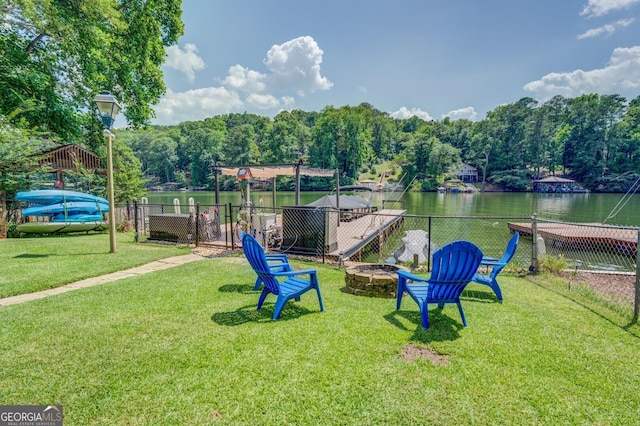 surrounding community with a yard, a water view, and an outdoor fire pit