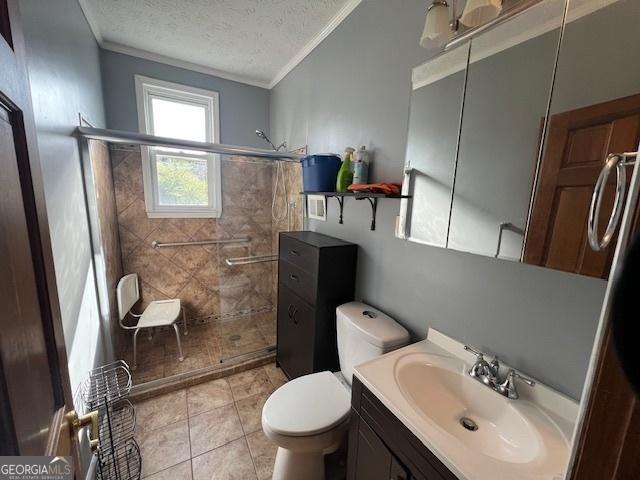 bathroom with a textured ceiling, crown molding, a stall shower, and vanity