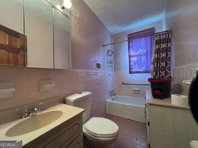 full bathroom with tile walls, a textured ceiling, toilet, and vanity
