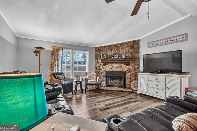 living room featuring crown molding, ceiling fan, a fireplace, and wood-type flooring