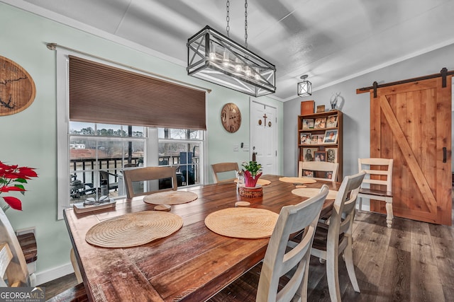 dining room featuring a barn door, dark wood-type flooring, and an inviting chandelier