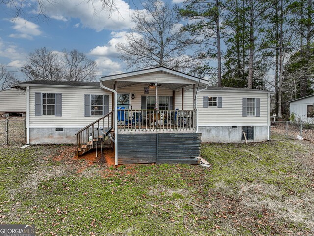 back of property with a porch, ceiling fan, and a lawn