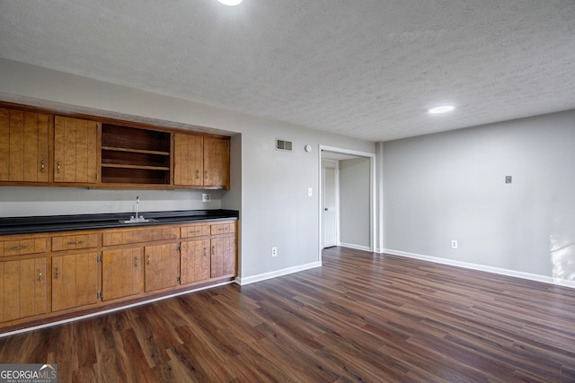 kitchen featuring sink, a textured ceiling, and dark hardwood / wood-style floors