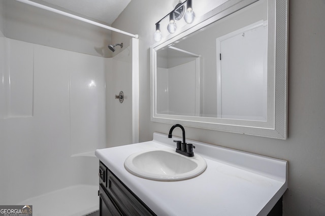 bathroom featuring vanity and a shower