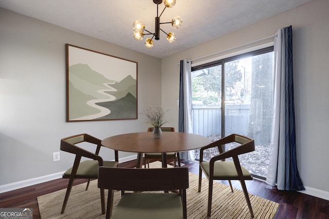 dining space with a textured ceiling, a notable chandelier, and dark hardwood / wood-style floors