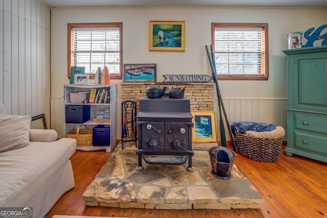 living area featuring wood-type flooring and a wood stove