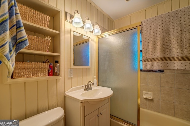 full bathroom with combined bath / shower with glass door, vanity, and toilet