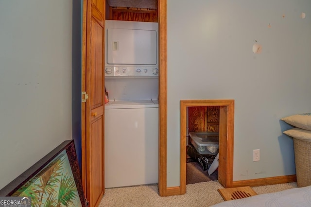 washroom with light carpet and stacked washing maching and dryer