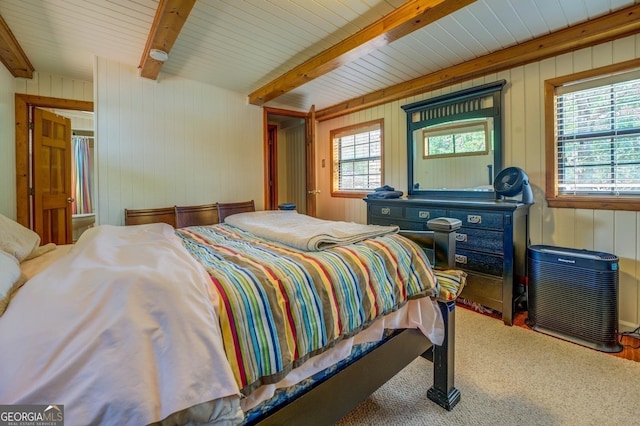 bedroom featuring beam ceiling and wooden walls