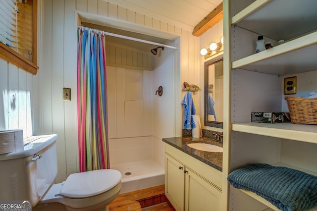 bathroom with vanity, a shower with curtain, wooden walls, toilet, and beamed ceiling