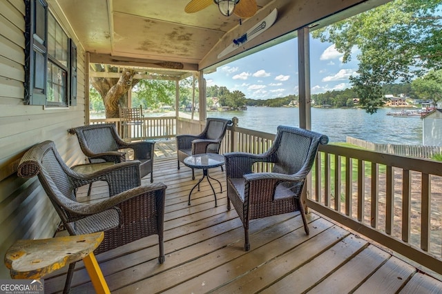 wooden terrace with ceiling fan and a water view