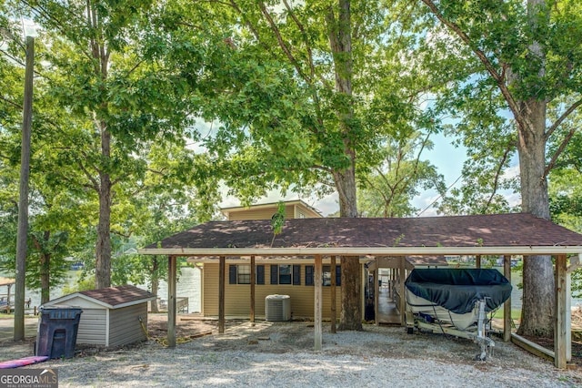 view of front of home featuring a storage unit, a carport, and central air condition unit