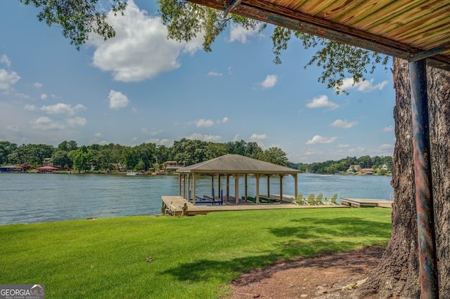 dock area featuring a lawn and a water view