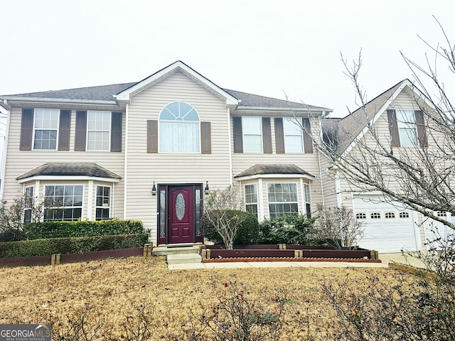 view of front of house featuring a garage and a front lawn