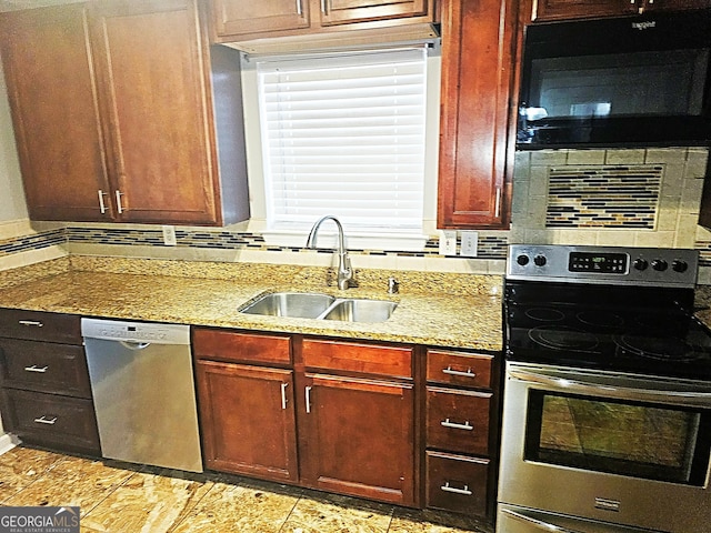 kitchen featuring light stone countertops, sink, stainless steel dishwasher, and range