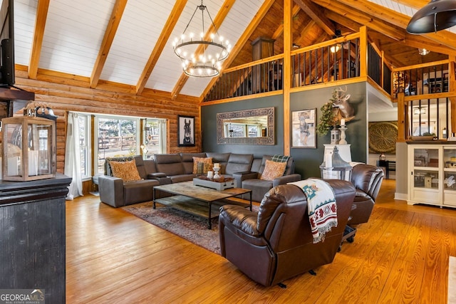 living room with wood-type flooring, high vaulted ceiling, rustic walls, and a notable chandelier