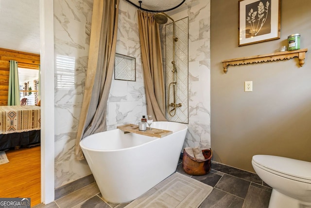 bathroom featuring shower with separate bathtub, toilet, and tile walls