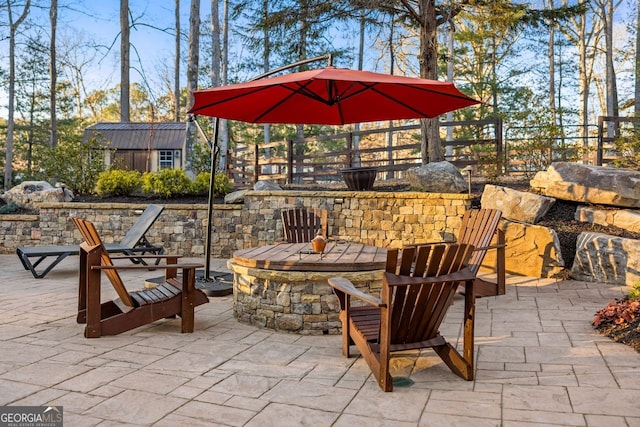 view of patio / terrace with a storage shed and an outdoor fire pit