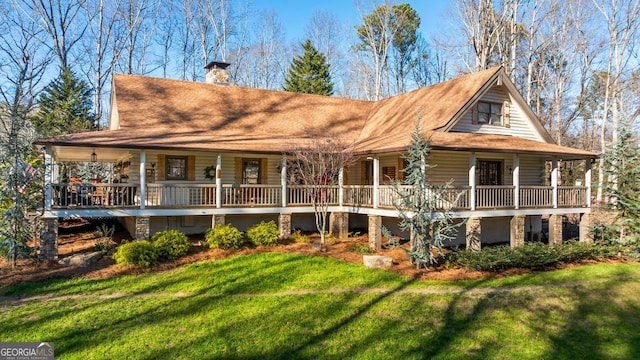 rear view of house featuring a porch and a yard