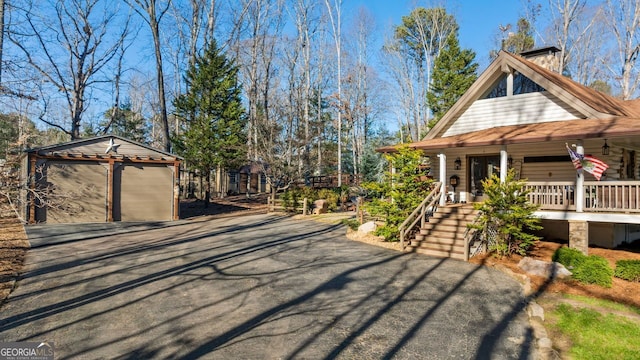 exterior space featuring a porch, a garage, and an outdoor structure