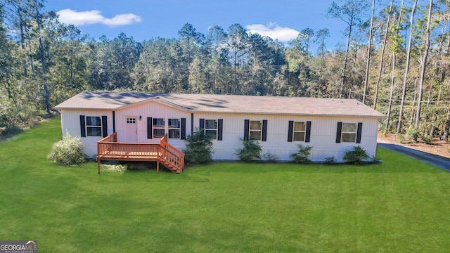 view of front of home featuring a front lawn and a deck