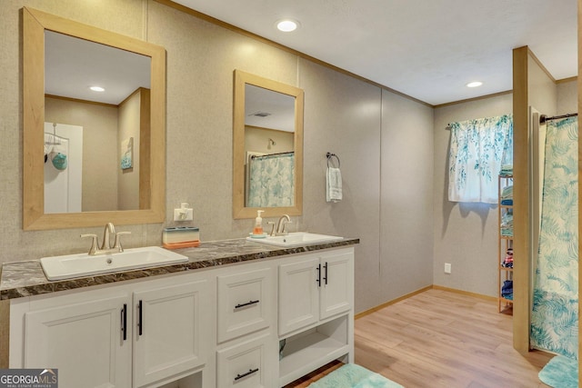 bathroom with hardwood / wood-style floors, vanity, and ornamental molding