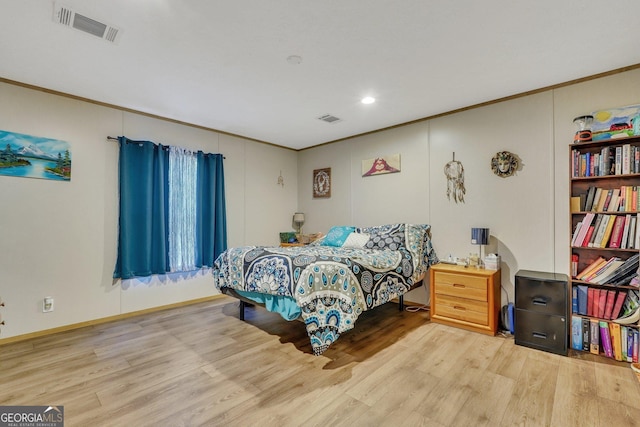 bedroom with light wood-type flooring and crown molding