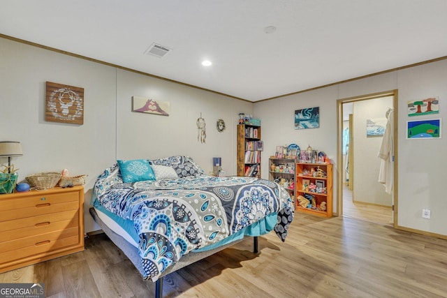 bedroom with wood-type flooring and crown molding