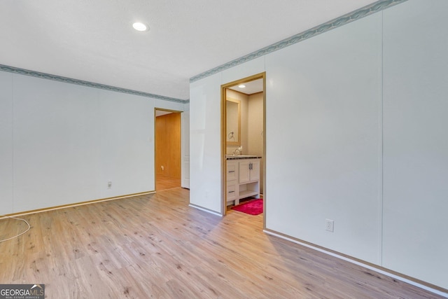 unfurnished room with sink and light wood-type flooring