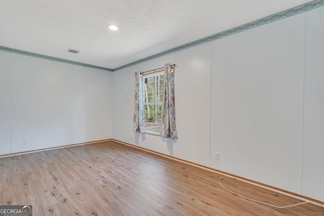 empty room featuring hardwood / wood-style floors and a textured ceiling