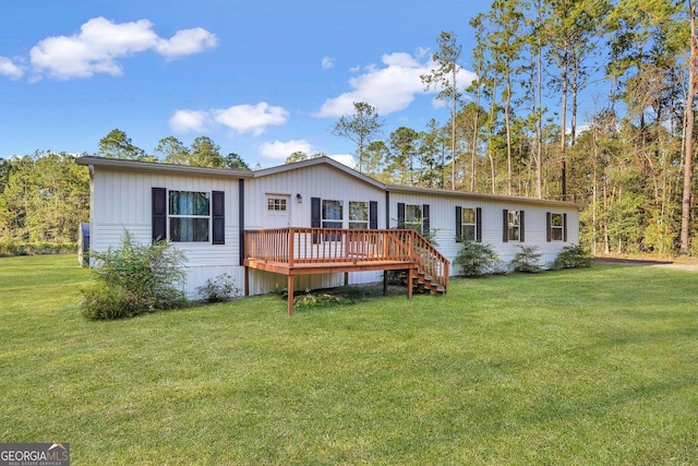 rear view of property featuring a yard and a wooden deck