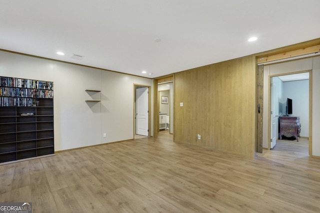 unfurnished living room featuring wood walls and light wood-type flooring