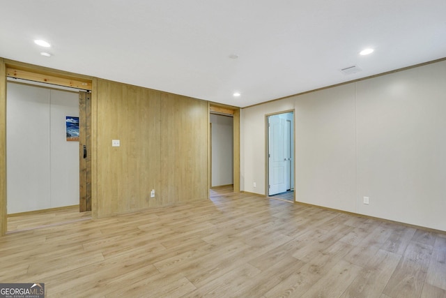 unfurnished room featuring crown molding and light hardwood / wood-style floors