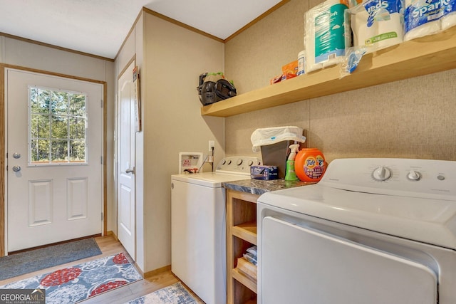 laundry room with washing machine and dryer, crown molding, and light hardwood / wood-style flooring