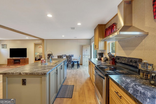 kitchen with stainless steel range with electric cooktop, wall chimney range hood, sink, light hardwood / wood-style flooring, and a large island