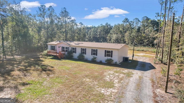 ranch-style house featuring a front lawn and central air condition unit