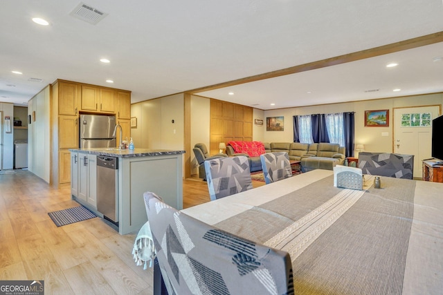 dining space with washer / dryer and light wood-type flooring