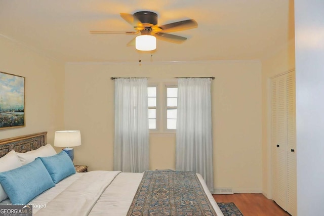 bedroom featuring light hardwood / wood-style floors, a closet, ornamental molding, and ceiling fan